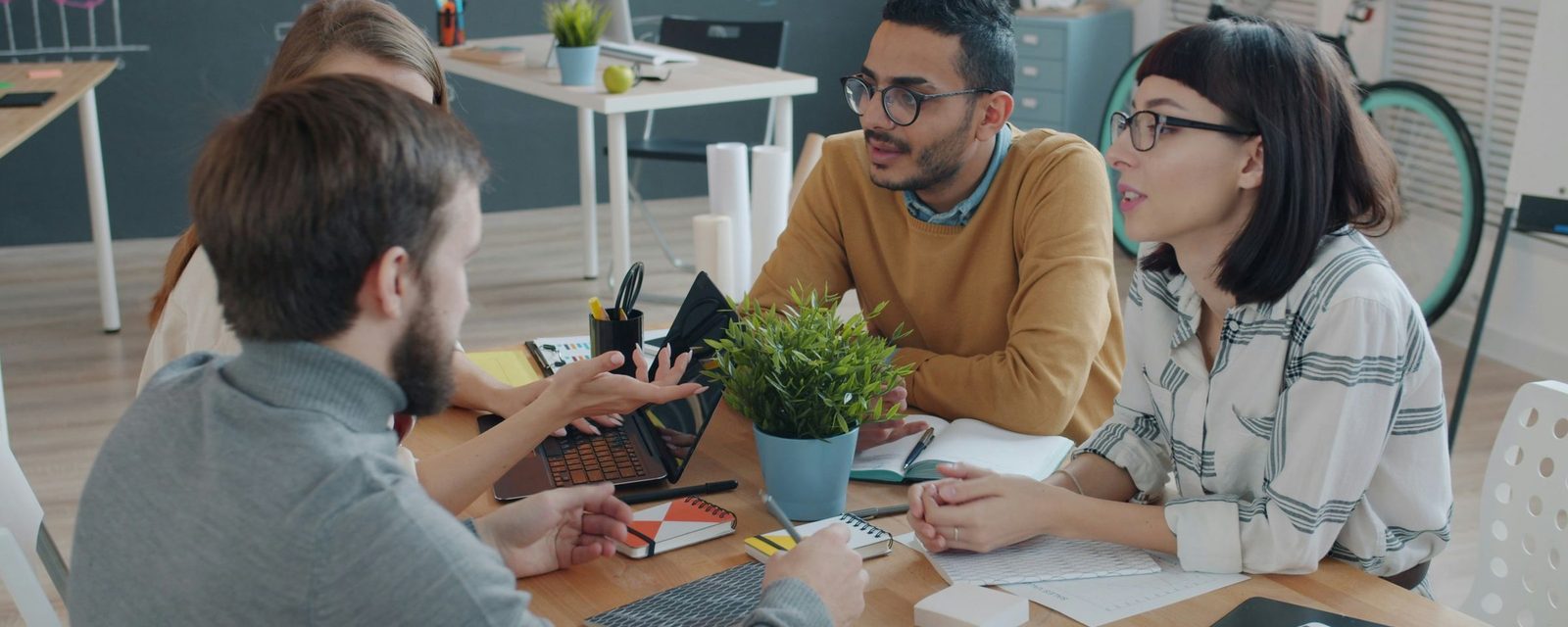 Team talking around a table in a bright office
